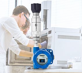 Senior male researcher carrying out scientific research in a lab using a gas chromatograph with a heated regulator super imposed over the top of the photo