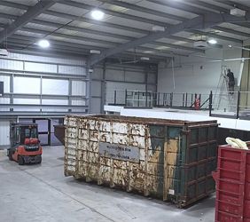 The interior of our new units being stripped out with two large industrial skips and a forklift truck in the foreground.
